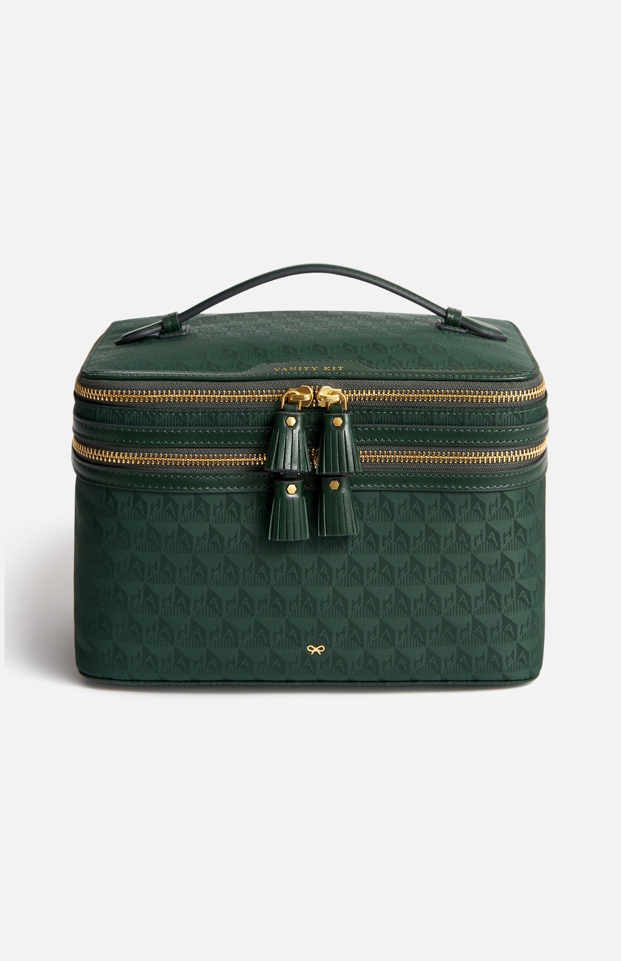 Anya Hindmarch Logo Vanity Kit: a dark green rectangular makeup brush organizer with a top handle, two-way zipper closures featuring tassel pulls, and an all-over repeating geometric pattern.