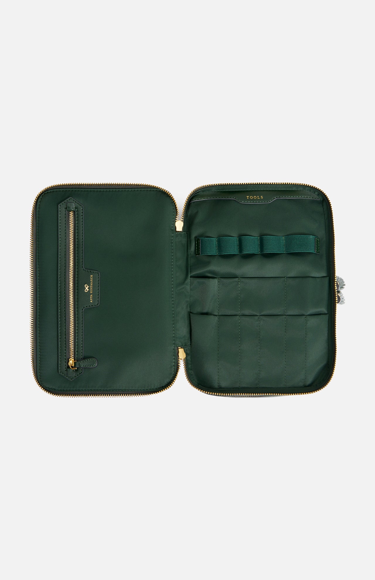Open dark green Anya Hindmarch Logo Vanity Kit with a zippered closure and interior slots and pockets labeled TOOLS.