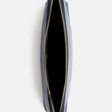 Top-down view of an open dark blue Anya Hindmarch Lotions and Potions Pouch.