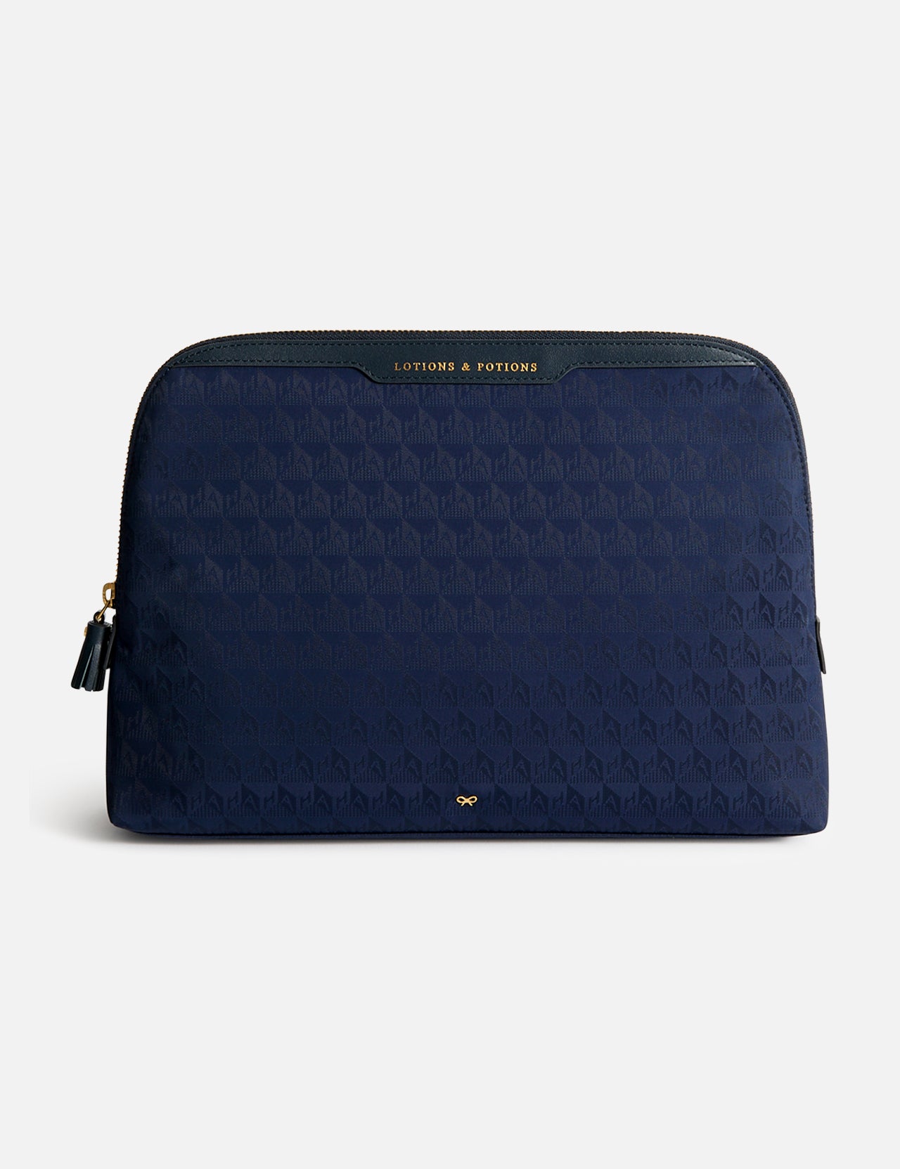 Navy blue Anya Hindmarch Lotions and Potions Pouch with a repeating geometric pattern and a gold-lettered LOTIONS & POTIONS label at the top.
