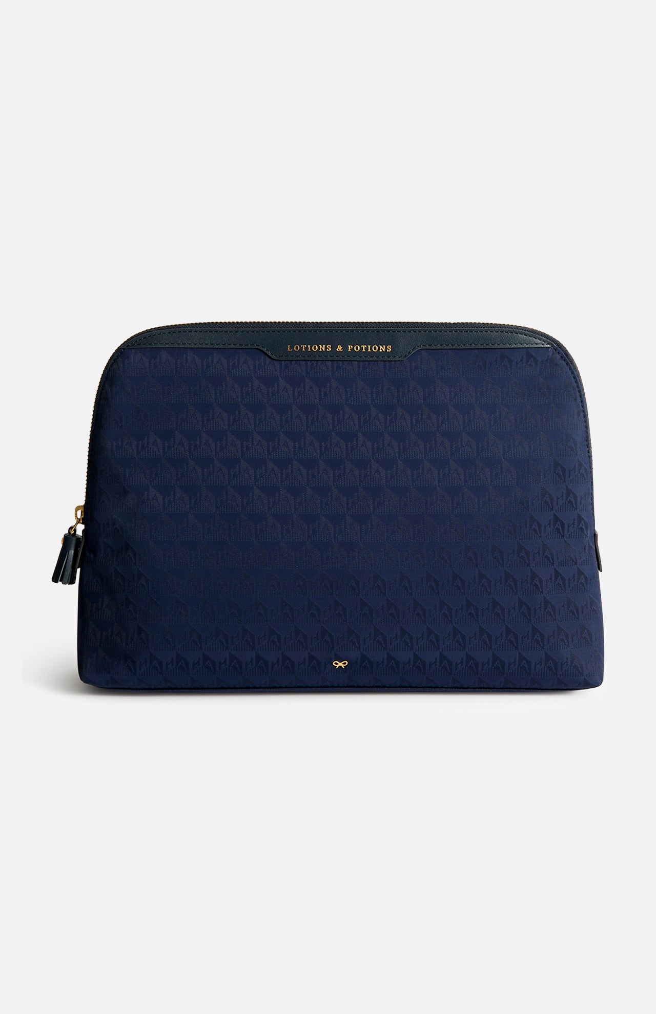 Navy blue Anya Hindmarch Lotions and Potions Pouch with a repeating geometric pattern and a gold-lettered LOTIONS & POTIONS label at the top.