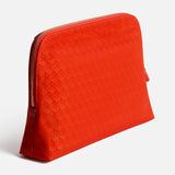 Anya Hindmarch Lotions and Potions Pouch in red with a zipper and repeating geometric pattern.