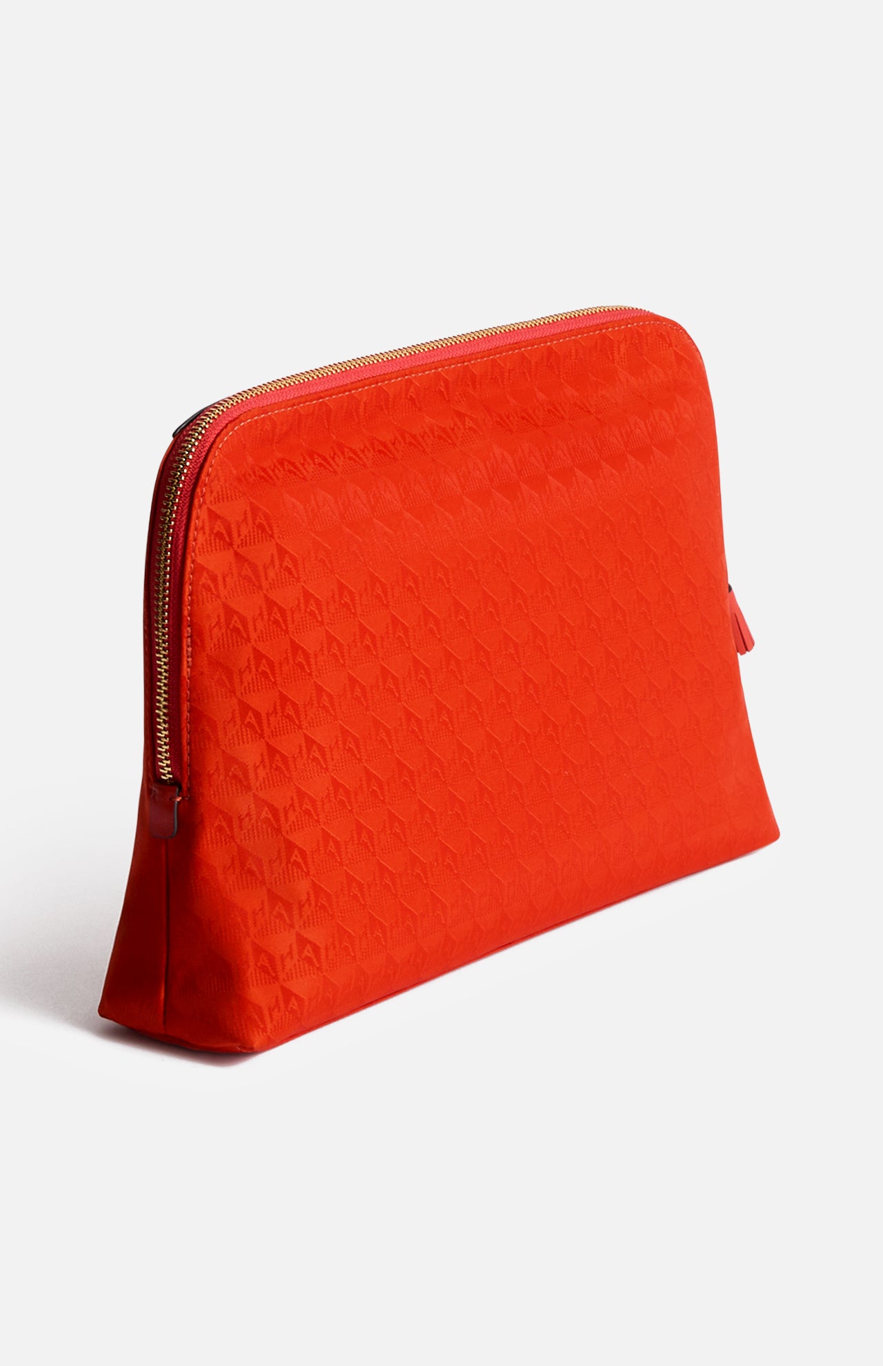 Anya Hindmarch Lotions and Potions Pouch in red with a zipper and repeating geometric pattern.
