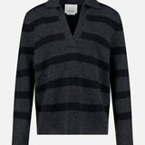 The Allen Wool Cashmere Oversized Sweater by ARLO MOTT features wide black horizontal stripes on a dark gray background, complemented by a V-neckline and collar. This charcoal stripe sweater is shown against a plain white backdrop.