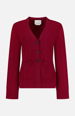 The Bleeker Shaped Cashmere Cardigan by ARLO MOTT is a red V-neck design, expertly knitted from luxurious Italian cashmere. It features long sleeves, three black buttons down the front, and two front pockets. Ribbed detailing at the cuffs and hem adds a refined touch. Presented against a plain white background.