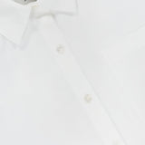 Close-up of the Clark Split Back Top by ARLO MOTT, a crisp white poplin shirt featuring a pointed collar, Mother of Pearl buttons, and a visible front pocket. The inside label shows the ARLO MOTT brand.