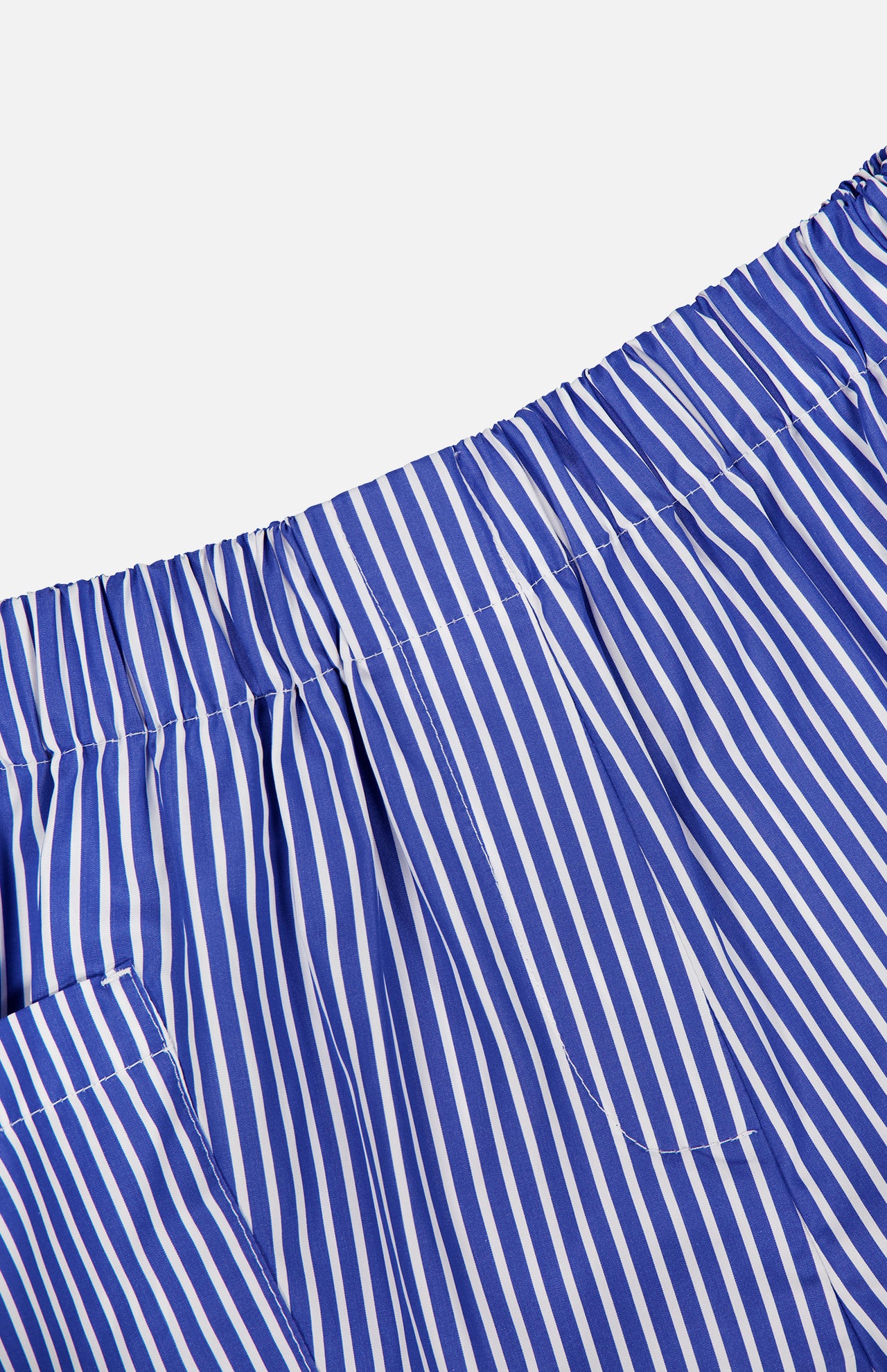 Close-up of ARLO MOTT Laight Striped Pocket Shorts in blue and white Portuguese poplin, featuring vertical stripes, an elastic waistband, and a left side pocket.