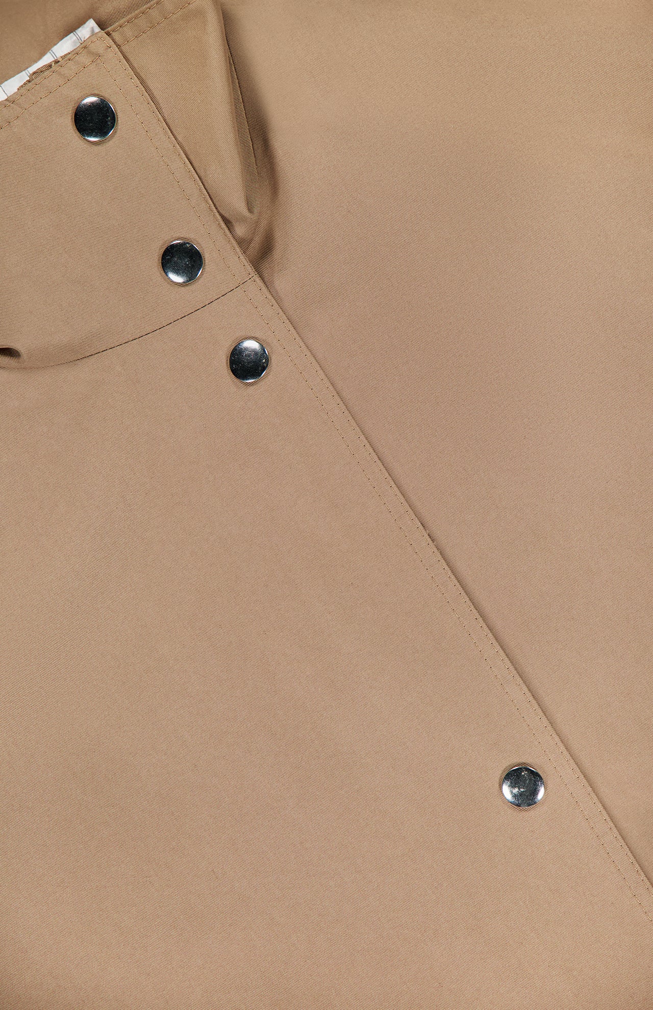 Close-up of the ARLO MOTT Logan Tech Water Resistant Jacket in tan Italian gabardine, showcasing a diagonal seam, four metallic snap buttons, and a top left pocket detail. The fabric offers water resistance for extra practicality.