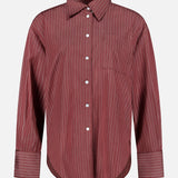 The ARLO MOTT Webster Striped Poplin Boyfriend Shirt features long sleeves, a button-up front, and thin white vertical stripes on an oxblood background, complete with a single chest pocket—perfect for fall styling.