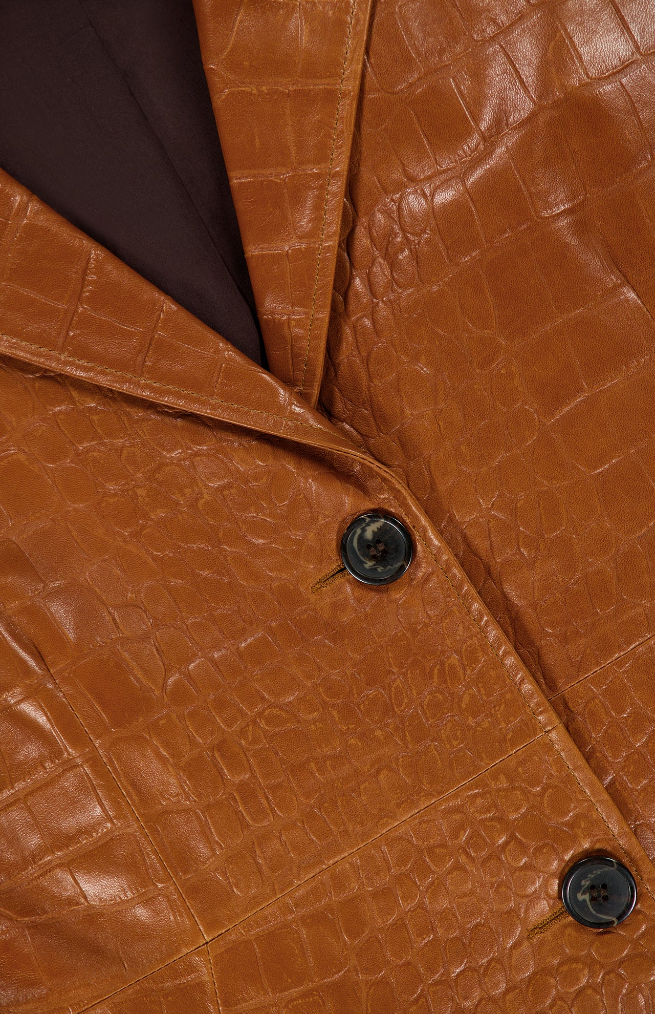 Close-up of the ARMA Aisa Lamb Nappa Print Trench Coat, featuring a rich brown faux-crocodile leather texture, two black buttons, a visible lapel, and fine stitching details.