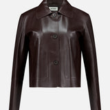 Crafted from dark brown lamb leather, the Emy Lamb Butter Coat by ARMA features a cropped, tailored silhouette with long sleeves, a collar, and three front buttons. The refined design is accented by the ARMA label visible inside the collar.