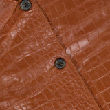 Close-up of the ARMA Emy Lamb Nappa Print Coat, featuring a brown crocodile-patterned leather design with black buttons and a visible ARMA label on the collar, highlighting the refined details of this tailored leather coat.