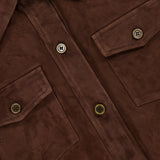 Close-up of the ARMA Faye Goat Suede Sturdy Coat, a brown suede button-up shirt-style coat featuring two chest pockets and visible buttons. A partial clothing label with the text ARMA is visible in the upper left corner.