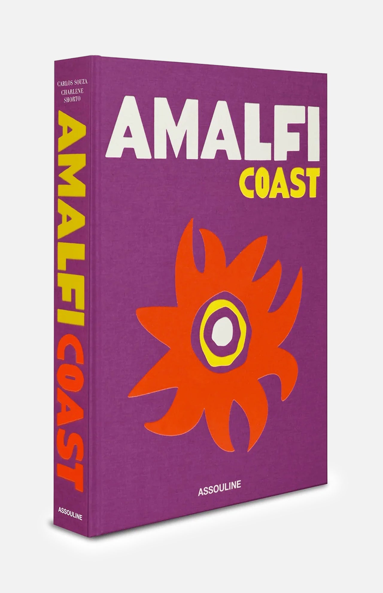 The ASSOULINE Amalfi Coast book features a striking purple cover accented with bold yellow and white text, along with an abstract orange and purple sun design that evokes the dreamy spirit of Italy’s Mediterranean coastline. The spine is also labeled “Amalfi Coast,” and it is published by ASSOULINE.