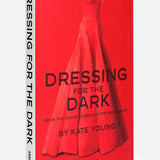 Dressing For The Dark by celebrity stylist Kate Young is a red book from ASSOULINE featuring a striking red evening gown on the cover. The subtitle, From the Silver Screen to the Red Carpet, suggests a focus on iconic moments in eveningwear fashion. The ASSOULINE brand name is displayed at the bottom of the cover.