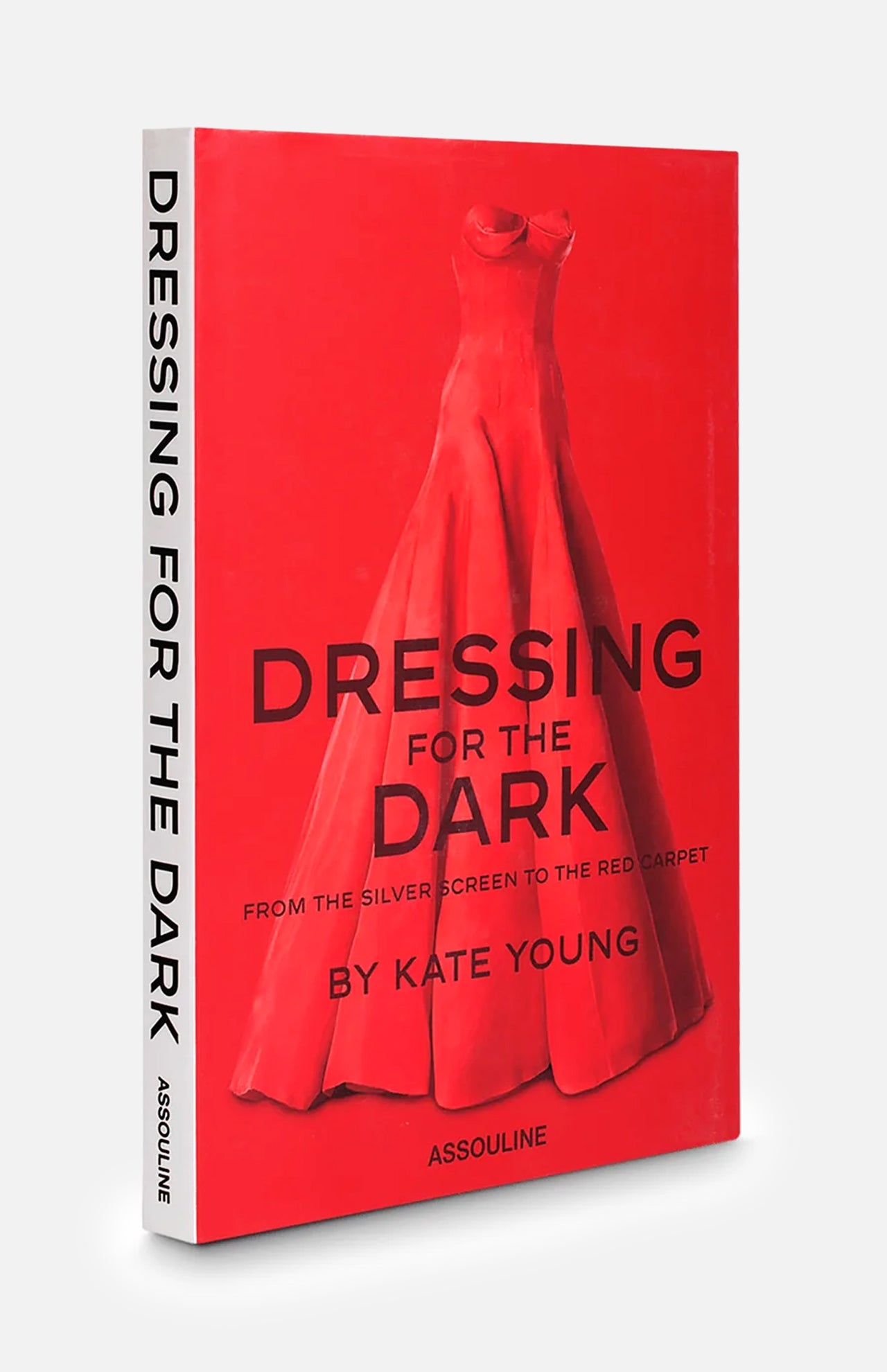 Dressing For The Dark by celebrity stylist Kate Young is a red book from ASSOULINE featuring a striking red evening gown on the cover. The subtitle, From the Silver Screen to the Red Carpet, suggests a focus on iconic moments in eveningwear fashion. The ASSOULINE brand name is displayed at the bottom of the cover.