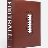 ASSOULINE’s "Football: The Impossible Collection" is a tribute to NFL and college football history, featuring a brown leather cover like a football, with white laces and FOOTBALL in bold white letters on the spine.