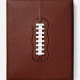 Inspired by college football and NFL history, Football: The Impossible Collection by ASSOULINE features a brown, square leather cover with a white lace cutout evoking the iconic laces of an American football.