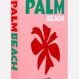 A pink hardcover book titled Palm Beach by ASSOULINE, featuring bold green and white text and a red flower graphic on the cover, perfectly captures the allure of this exclusive community renowned for its luxury resorts.