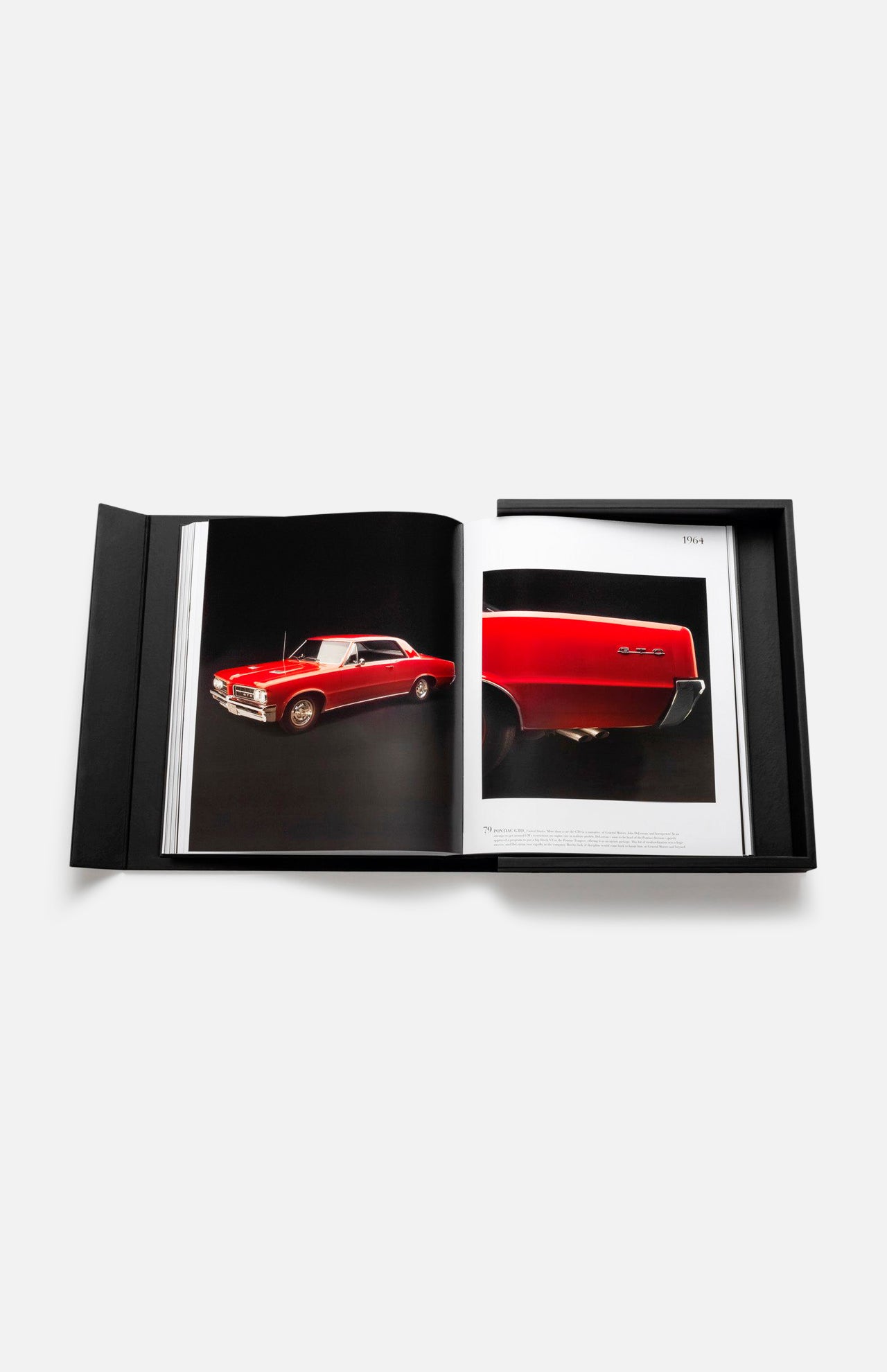 The Impossible Collection of Cars by ASSOULINE is displayed open inside its black box, featuring striking photos of classic cars—like a red vintage model—on white pages, all set against a plain white background.