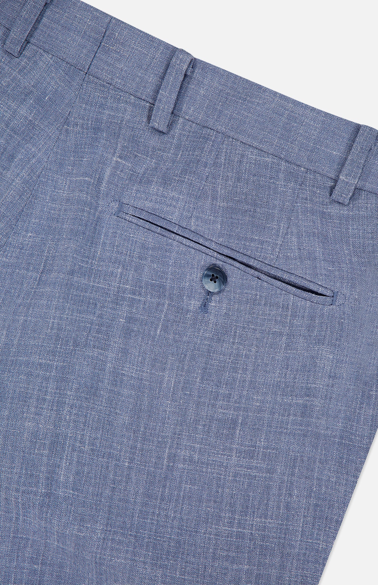 Close-up of the back pocket of light blue Melange Wool Silk and Linen Suit dress pants by ATELIER MUNRO, featuring a single button closure and waistband belt loops.