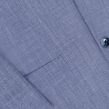 Close-up of the Melange Wool Silk and Linen Suit by ATELIER MUNRO, highlighting a front pocket, part of the sleeve, and two blue buttons on the single-breasted light blue jacket.
