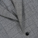 Close-up of the Peak Lapel Plaid Suit by ATELIER MUNRO, featuring black and white plaid fabric, a defined lapel, detailed stitching, and button—ideal for formal occasions or a timeless wool suit look.