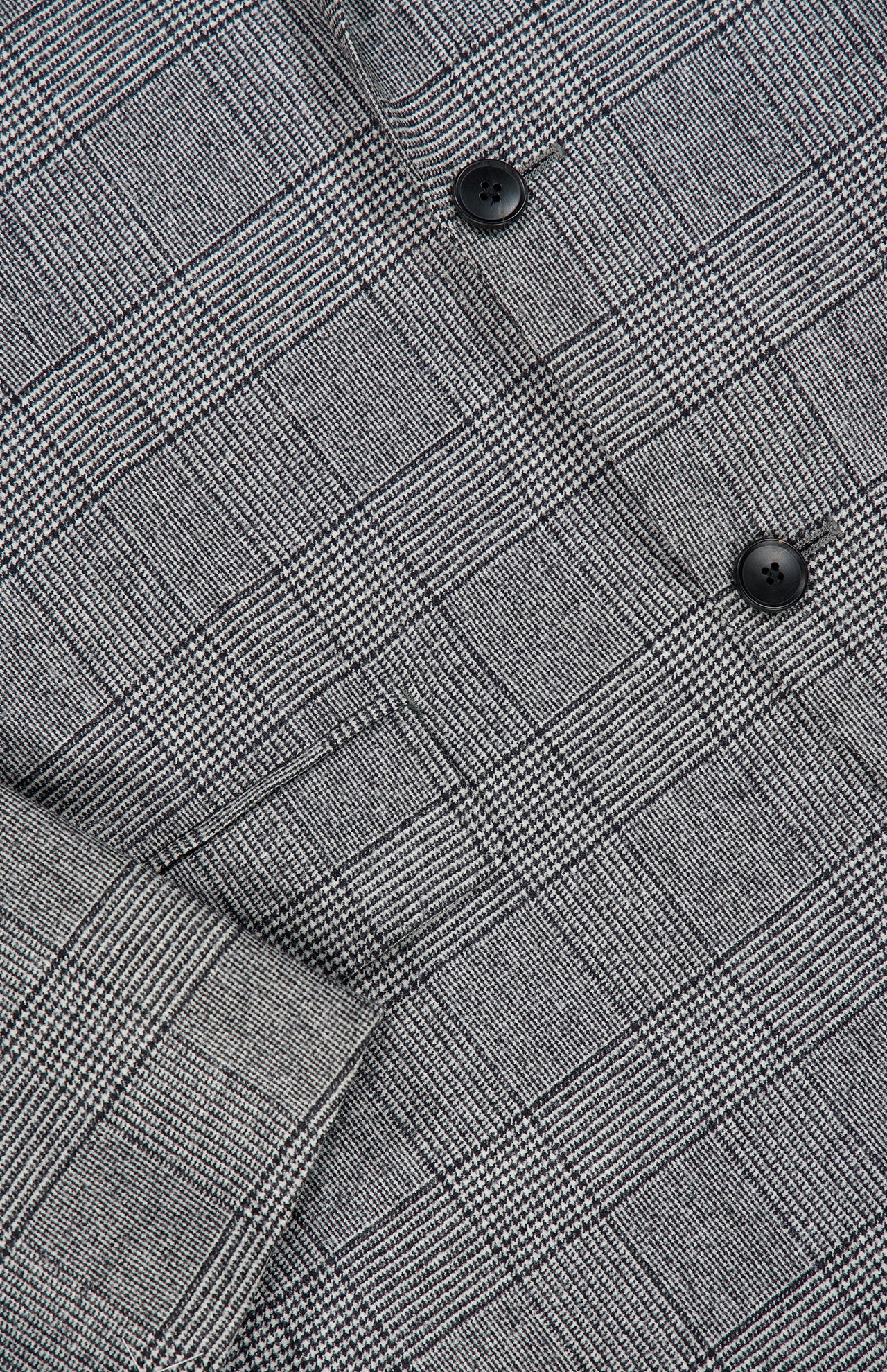 Close-up of the ATELIER MUNRO Peak Lapel Plaid Suit, featuring a gray wool fabric in black and white plaid with black buttons—perfect for formal occasions.