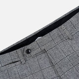 Close-up of the Peak Lapel Plaid Suit by ATELIER MUNRO, featuring gray wool fabric with black button and belt loops, ideal for formal events, shown against a white background.