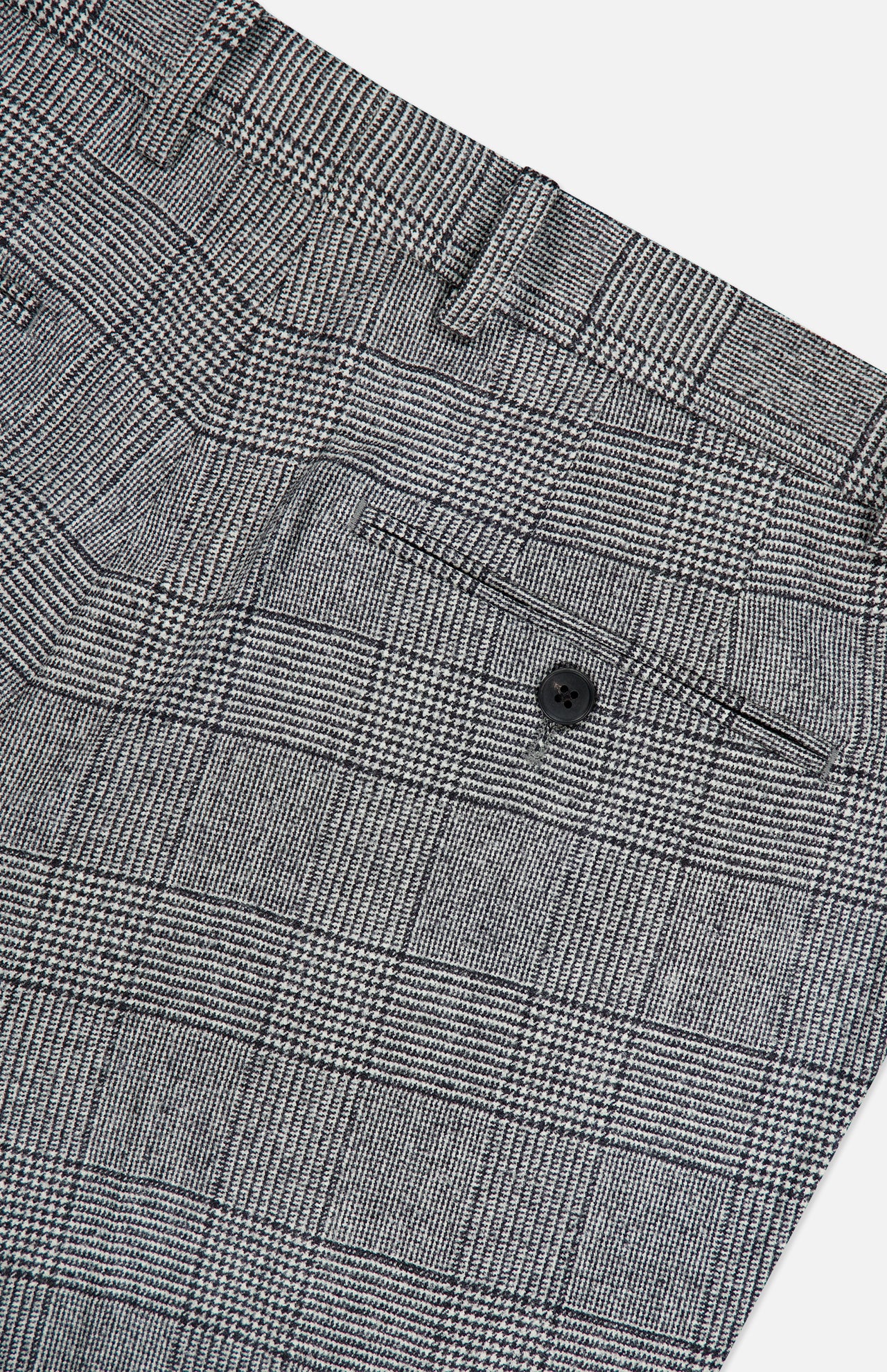 Close-up of the Peak Lapel Plaid Suit by ATELIER MUNRO, featuring gray checkered wool fabric, a black back pocket button, and belt loops—ideal for formal occasions.