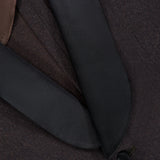 Close-up of the ATELIER MUNRO Shawl Lapel Tuxedo Suit featuring a pure wool jacket with black satin shawl lapel, brown inner lining, fine stitching, and a fabric-covered button.