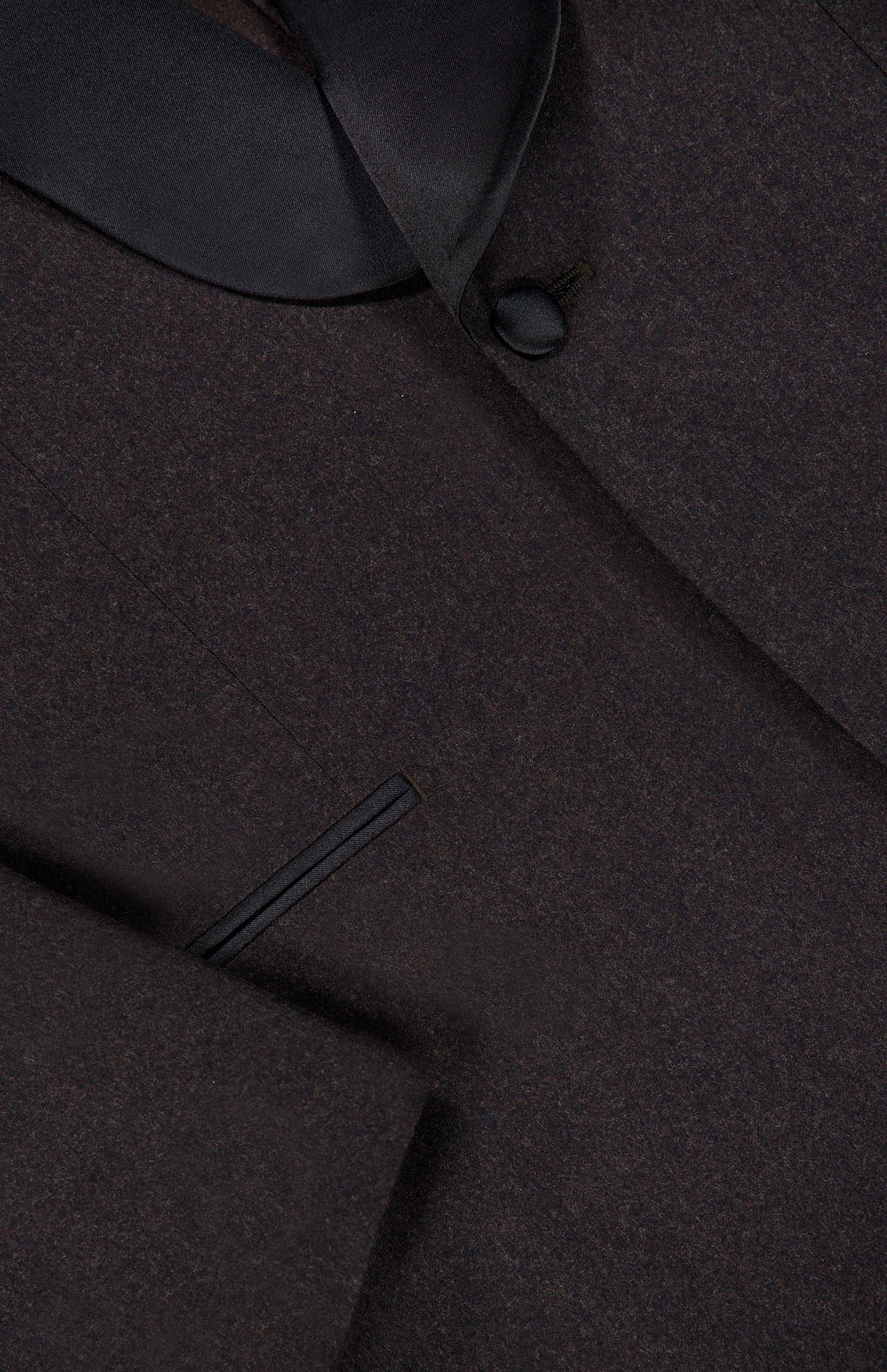Close-up of the ATELIER MUNRO Shawl Lapel Tuxedo Suit in dark brown pure wool, featuring a black satin shawl lapel, single button closure, and welt pocket detail with visible fine tailoring.