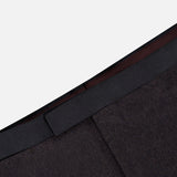 Close-up of the waistband and upper section of the Shawl Lapel Tuxedo Suit by ATELIER MUNRO, featuring a dark brown jacket, black waistband, and shawl lapel against a light gray background.