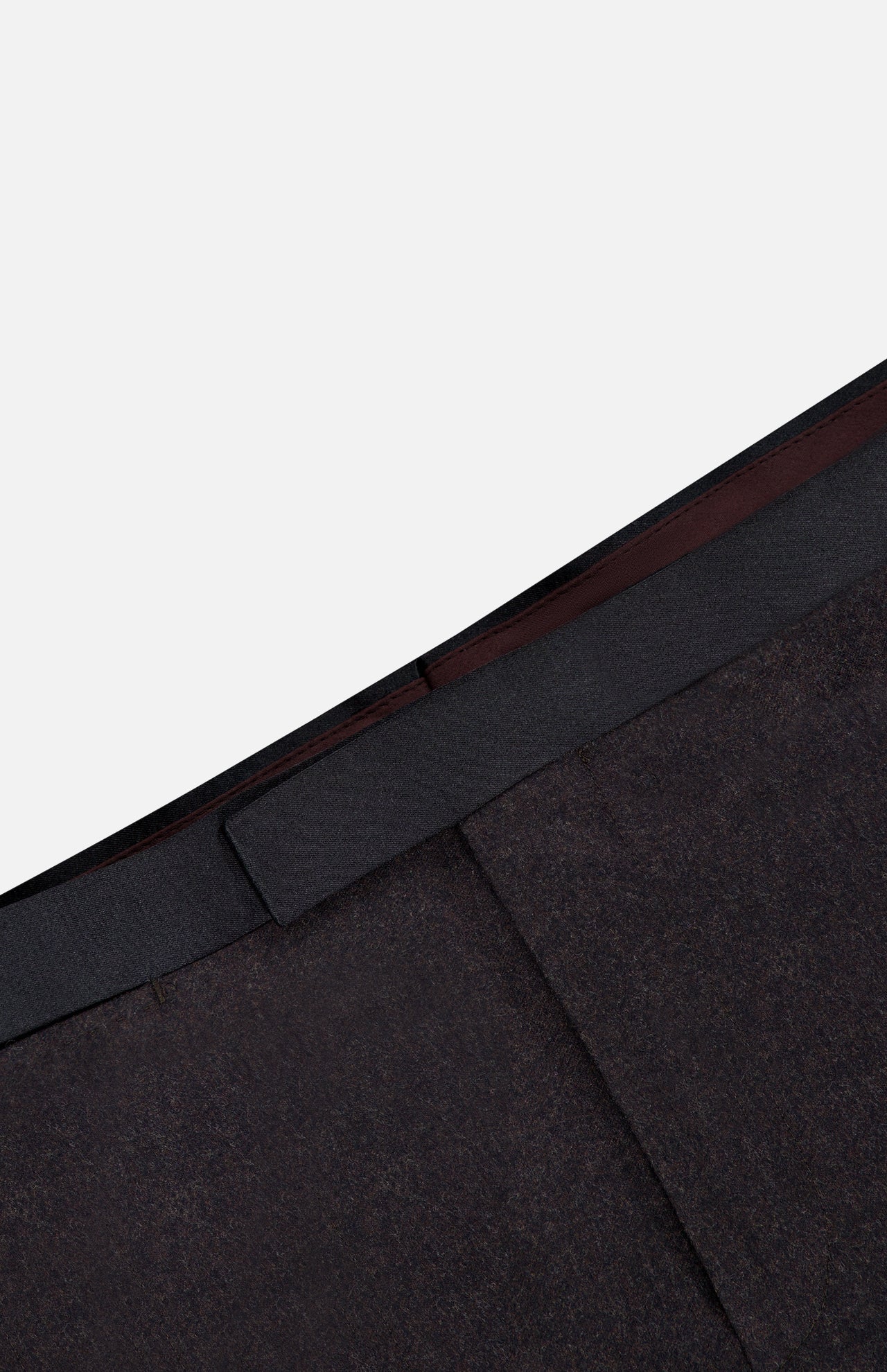 Close-up of the waistband and upper section of the Shawl Lapel Tuxedo Suit by ATELIER MUNRO, featuring a dark brown jacket, black waistband, and shawl lapel against a light gray background.