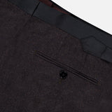 Close-up of the back pocket on dark dress pants from the Shawl Lapel Tuxedo Suit by ATELIER MUNRO, featuring a single-button closure and black waistband detail against a light background.