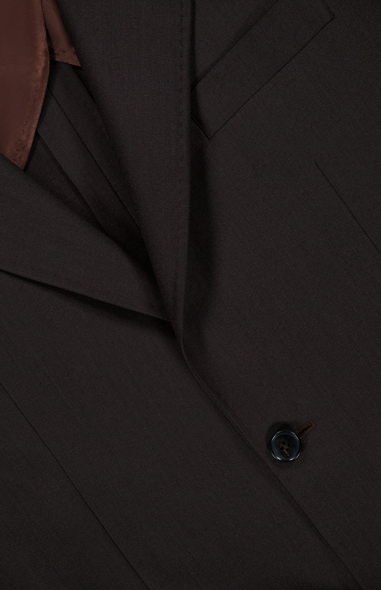 Close-up of the ATELIER MUNRO Wide Notch Lapel Solid Suit: dark brown wool blend, notched lapel, chest pocket, brown lining, and single black button—ideal for formal occasions.