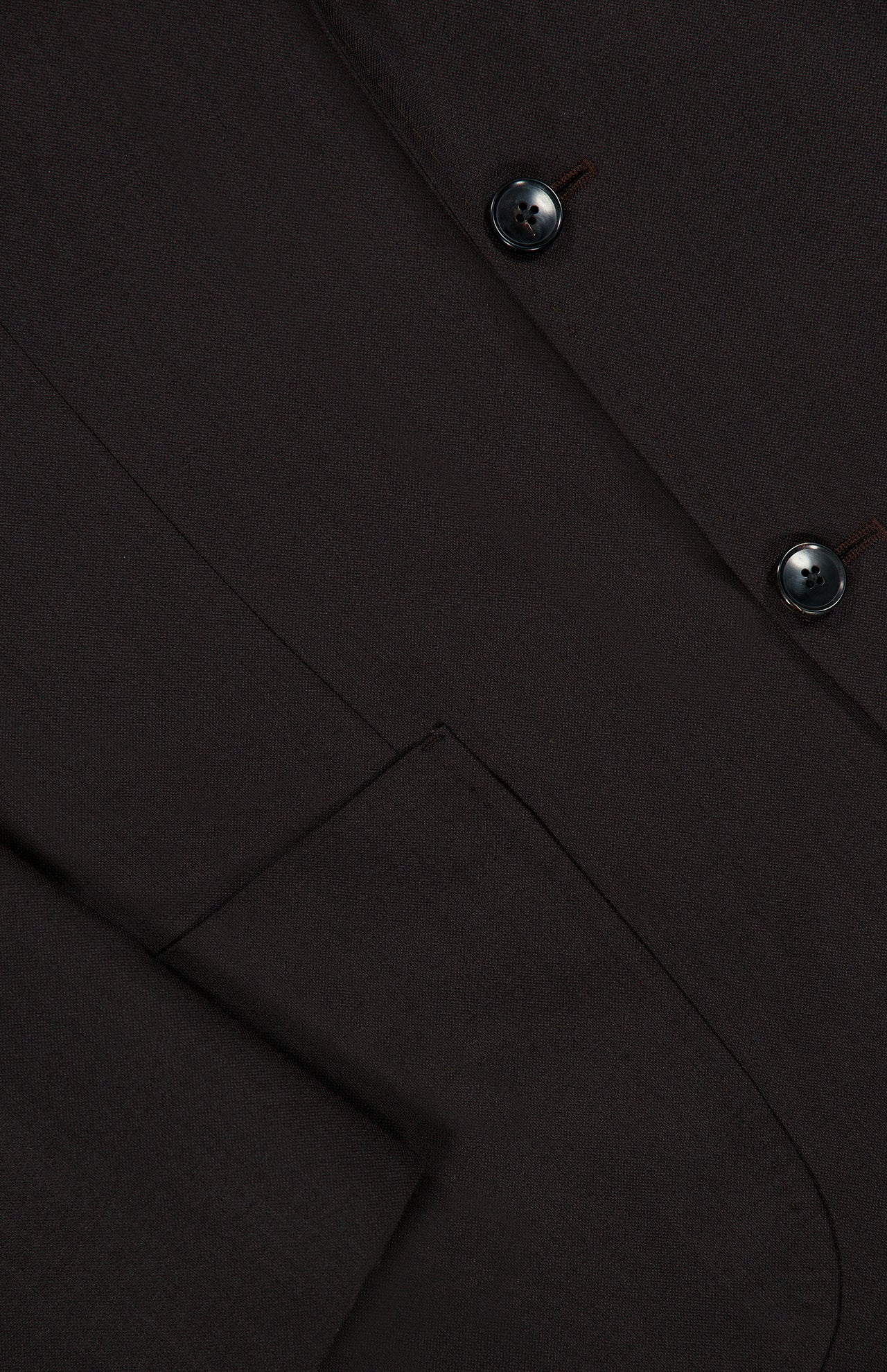 Close-up of the ATELIER MUNRO Wide Notch Lapel Solid Suit in dark brown, highlighting the pocket, lapel, and two black buttons.