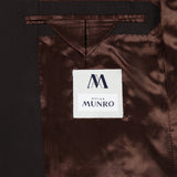 The inside of the Wide Notch Lapel Solid Suit by ATELIER MUNRO features shiny brown lining, a white Atelier Munro label, and a small chest pocket above it—a refined detail in this formal suit.
