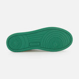 The Medalist Low Bicolor Sneakers by AUTRY feature a green platform sole with circular and linear tread patterns and the AUTRY logo embossed at the center, set against a plain white background.