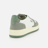 The AUTRY Medalist Low Leather Suede Sneaker is a stylish white 1980s-inspired tennis shoe with green suede accents, platform sole, green heel tab, and Autry branding on the side and heel, shown from a rear diagonal angle on a white background.