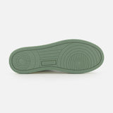 The AUTRY Medalist Low Leather Suede Sneaker features a green rubber platform sole with circular and linear treads and “AUTRY” embossed in the center, recalling vintage 1980s tennis shoes. Shown on a plain white background.