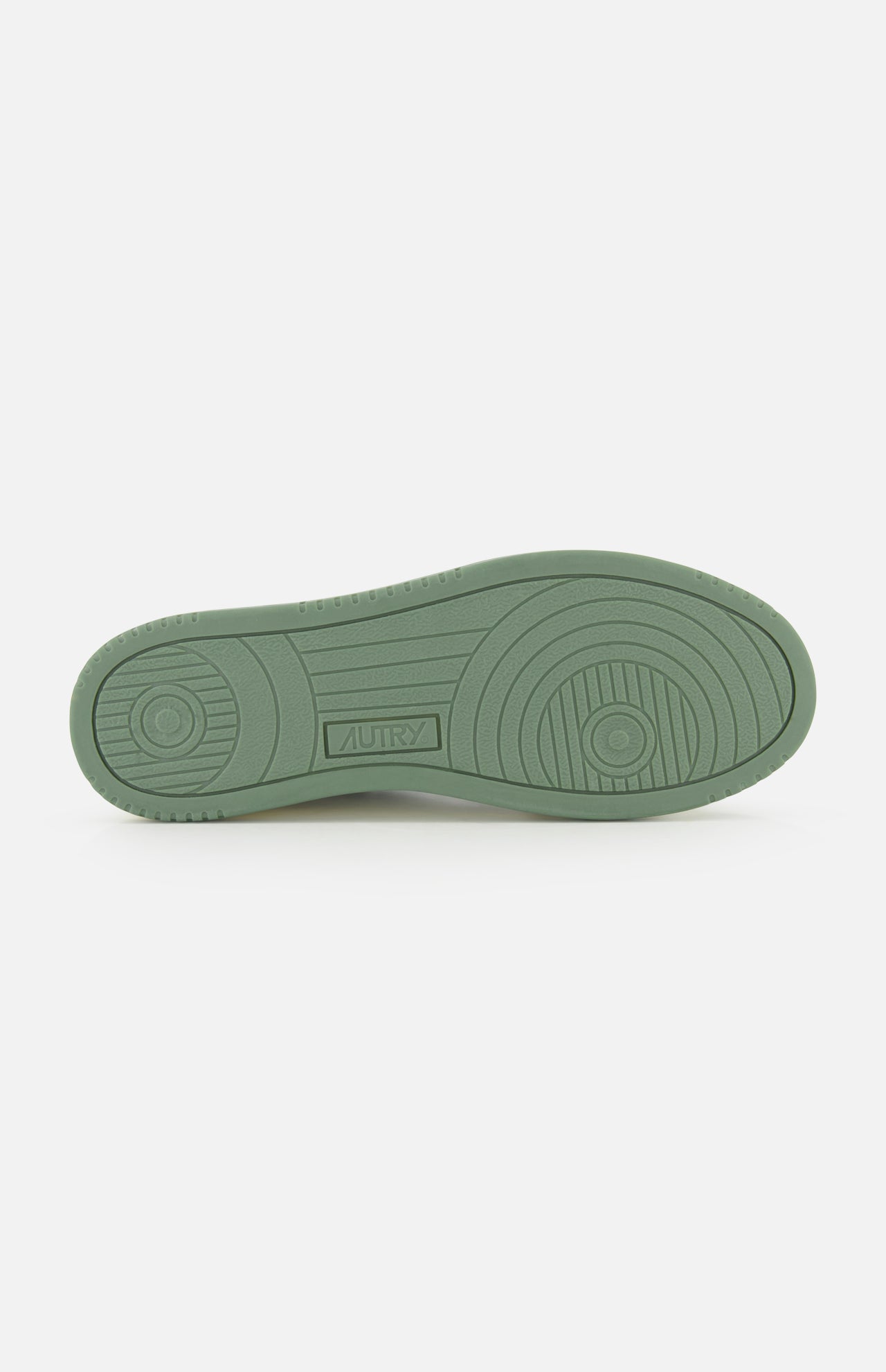 The AUTRY Medalist Low Leather Suede Sneaker features a green rubber platform sole with circular and linear treads and “AUTRY” embossed in the center, recalling vintage 1980s tennis shoes. Shown on a plain white background.