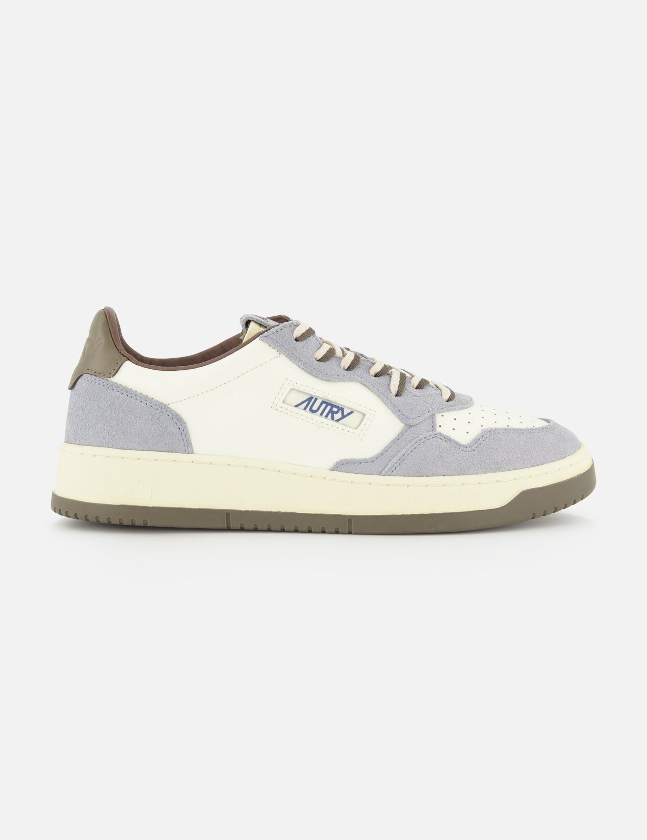 The AUTRY Medalist Low Man Leather Suede Sneaker is a white and gray low-top inspired by 1980s tennis shoes, crafted with suede and leather panels, gray laces, and the signature Autry logo on the side. The sneaker is finished with a cream sole, brown heel tab, and classic retro styling throughout.