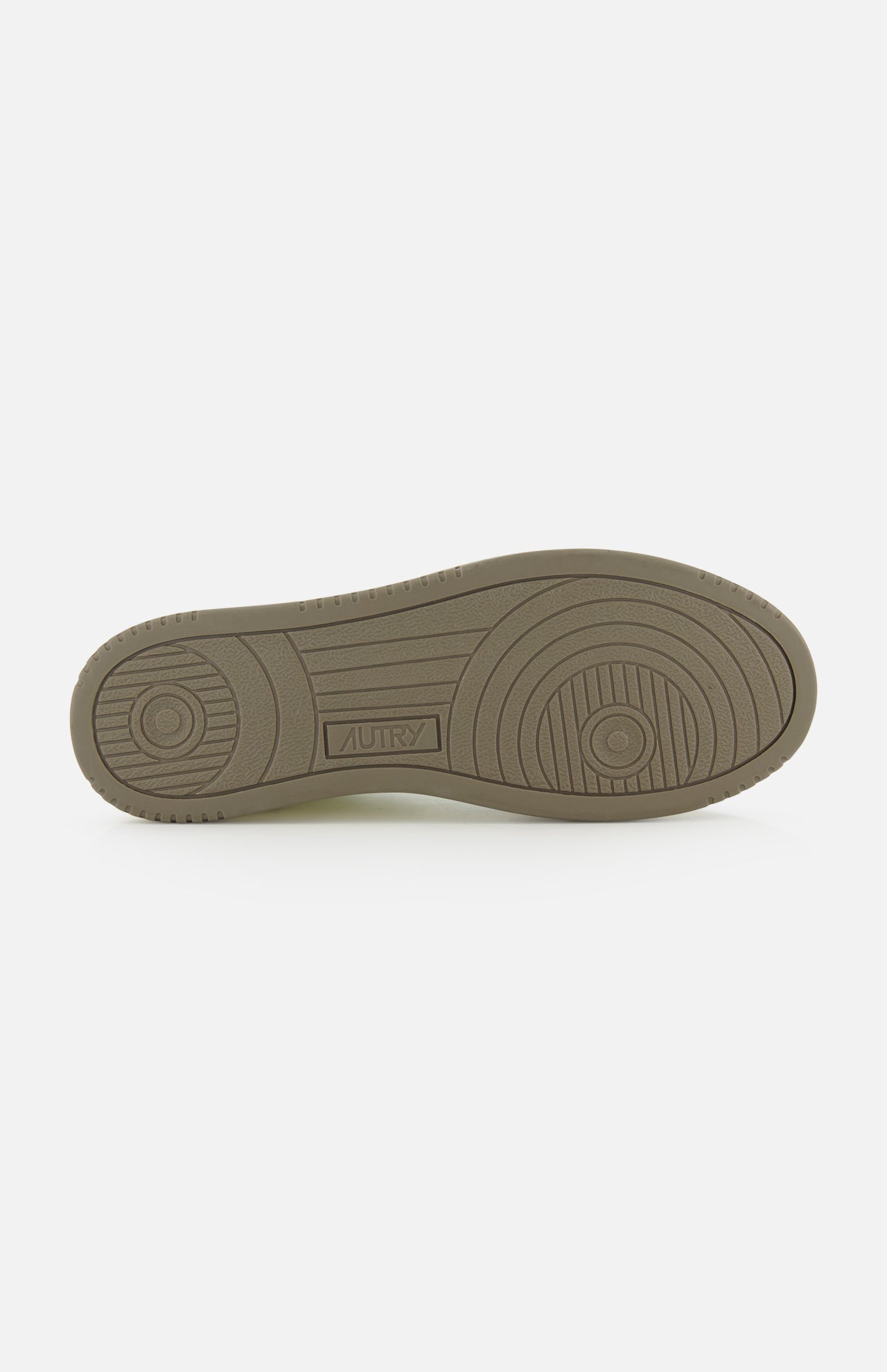 The image features the sole of the AUTRY Medalist Low Man Leather Suede Sneaker in beige, displaying various textured patterns and an AUTRY embossing near the arch, evoking the style of classic 1980s tennis shoes.