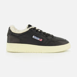 The Medalist Low Man Shearling Sneaker by AUTRY is a black low-top leather sneaker featuring a cream platform sole, plush shearling lining, and a small AURA logo patch with red, white, and blue stripes on the side. The shoe is shown against a plain white background.