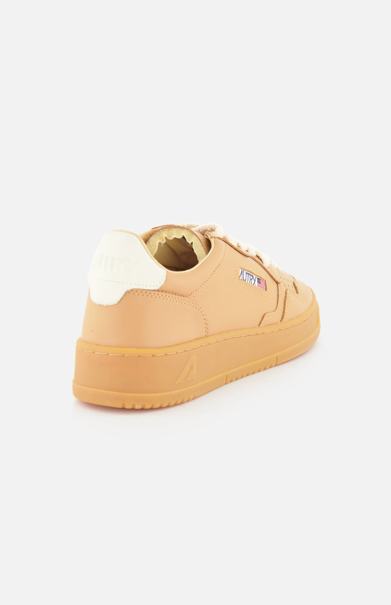 The AUTRY Medalist Low Man Sneaker with Knit Laces is a tan low-top shoe with a white heel tab, beige knit laces, a small rectangular side logo, and a platform sole, shown from a rear side angle on a white background.