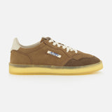 The Medalist Low Man Suede Leather Sneaker by AUTRY features brown suede uppers, a beige sole, cream laces, and a distinctive small side cutout that reveals patterned fabric beneath. Inspired by vintage tennis shoes, this low-top sneaker is showcased against a plain white background.