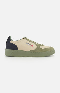 The AUTRY Medalist Low Man Suede Sneaker features a beige and green low-top design crafted from multicolored suede, highlighted by a green platform sole, a dark green heel, and the signature AUTRY logo with a small American flag on the side for a distinctive look.