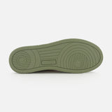 The AUTRY Medalist Low Man Suede Sneaker features an olive green sole with circular and linear tread patterns, and the AUTRY brand name embossed at the center. This low-top sneaker boasts a stylish design, displayed against a white background.