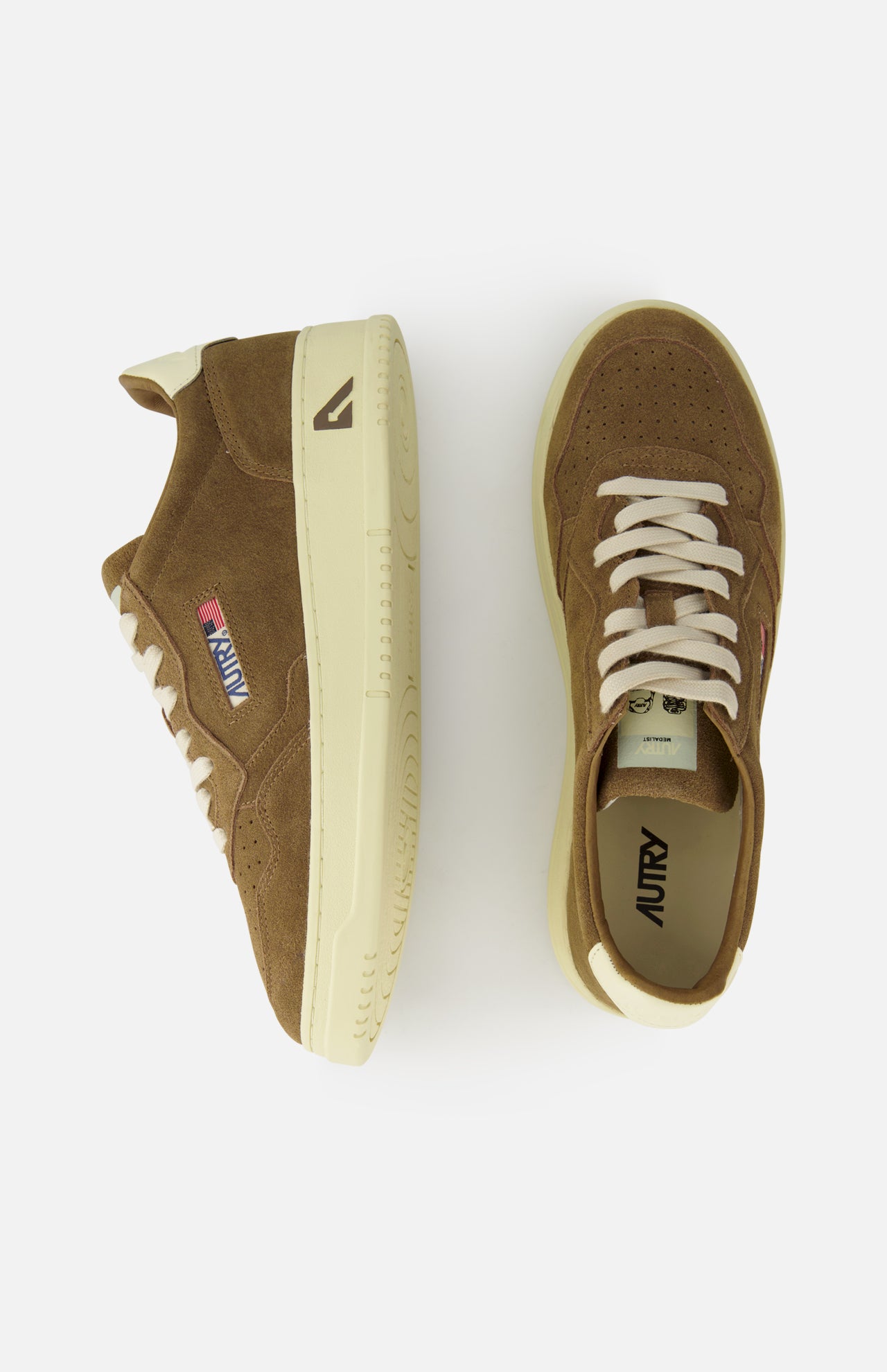 AUTRY Medalist Low Suede Sneakers in brown with cream soles and laces, shown from side and top on white. Features a stitched logo patch and retro 1980s tennis shoe-inspired design.